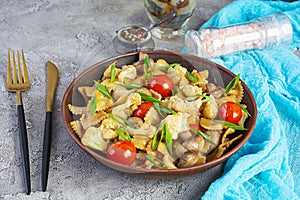 Stir fry farfalle pasta with vegetables, cauliflower and mushrooms