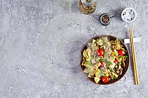 Stir fry farfalle pasta with vegetables, cauliflower and mushrooms. Top view