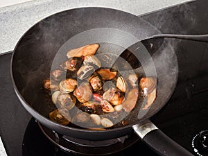 Stir-frying Ginger and clams at high heat to bring forth the savory aroma with sesame oil