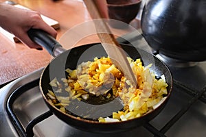 Stir the onion with spices using wooden spatula in the pan to cook dinner