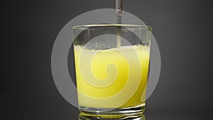 Stir the yellow mixture in a glass beaker with a spoon. Slow motion