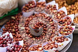 Stirred fire Peanuts topping with salt in paper cone at street local market in Darjeeling. India.