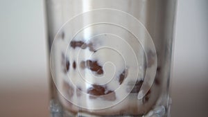 Stirring boba milk tea in a glass