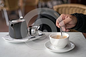 Stirring cup of coffee with a spoon