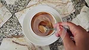 Stirring Milk in Cup of Coffee with Tea Spoon. Top View