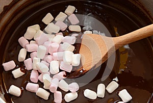Stirring mini marshmallows into melted chocolate