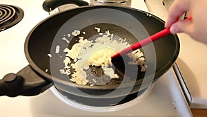 Stirring onions in a frying pan