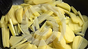 Stirring potatoes frying in a frying pan