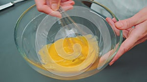 Stirring the raw yolk with a kitchen whisk