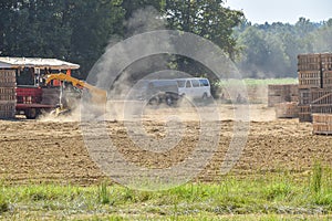 Stirring up dust in a north Mississippi sweet potato field. In the background are crates to place the potatoes in after picking th