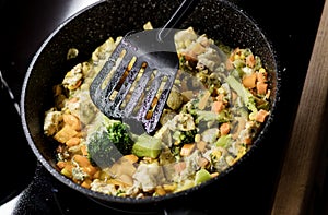 stirring vegetables in frying pan