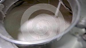 Stirring wort in a large steel vessel on a brewery factory.