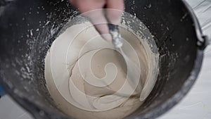 Stirs cement or mortar mixed with water, top view and close-up. Mixed mortar cement in container ready to be used. The
