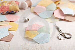 Stitched quilting block from four pentagons, piles of blocks and pentagons, sewing accessories