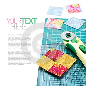 Stitched square pieces of fabric of quilt with rotary knife and