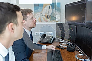 Stock brokers looking at computer screens, trading online.
