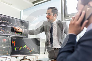 Stock brokers looking at computer screens, trading online.