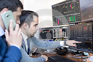 Stock brokers looking at computer screens, trading online.