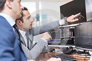 Stock brokers looking at computer screens, trading online.