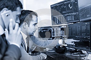 Stock brokers trading online in corporate office.