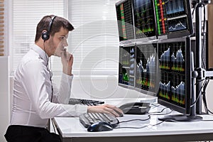 Stock Market Broker Analyzing Graphs On Computer Screens