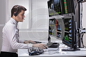 Stock Market Broker Analyzing Graphs On Computer Screens