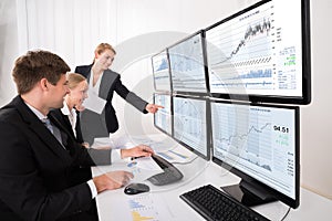 Stock Market Brokers Looking At Graphs On Multiple Computer