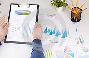 Stock market chart and finger pointing on tablet in office