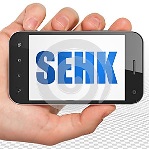 Stock market indexes concept: Hand Holding Smartphone with SEHK on display photo