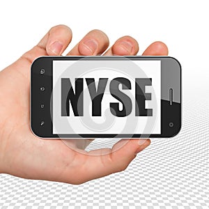 Stock market indexes concept: Hand Holding Smartphone with NYSE on display photo