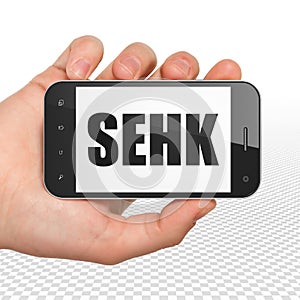 Stock market indexes concept: Hand Holding Smartphone with SEHK on display photo