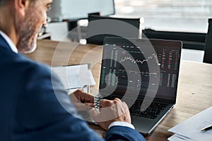 Stock market Investor analyzing crypto market on computer screen. Over shoulder