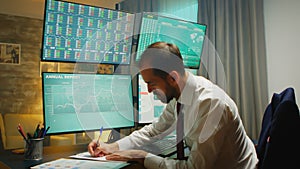 Stock market trader pointing at monitor computer