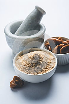 Stock Photo of Asafoetida powder / Hing or Heeng with cake and mortar