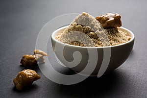 Stock Photo of Asafoetida powder / Hing or Heeng with cake and mortar