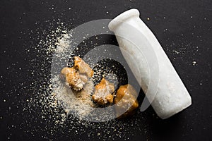 Stock Photo of Asafoetida powder / Hing or Heeng with cake and mortar