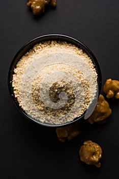 Stock Photo of Asafoetida powder / Hing or Heeng with cake and mortar