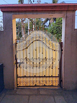 Stock photo of black color painted iron metal Indian style gate cover with fiber glass in the front yard of the house. Picture