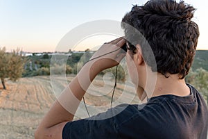 Young Unrecognized Boy Using Binoculars