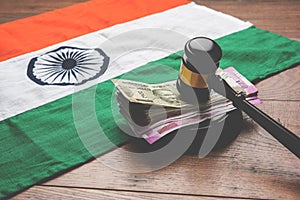 Stock photo of Indian Currency Rupee Notes with Law Gavel isolated on white, concept showing indian finance law with paper currenc