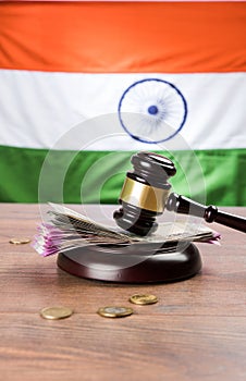 Stock photo of Indian Currency Rupee Notes with Law Gavel isolated on white, concept showing indian finance law with paper currenc