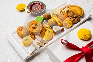 Indian sweets or Mithai for diwali festival with oil lamp or diya and gift box photo