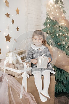 Little beautiful girl near the festive christmas tree