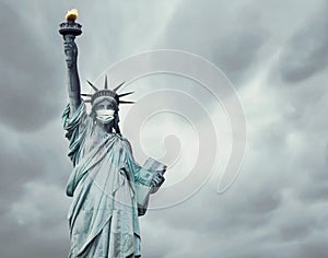 Stock photo of the New York`s Statue of Liberty with a mask caused by the coronavirus and copy space