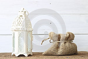 Stock Photo:Oriental lantern on wooden table in the evening.