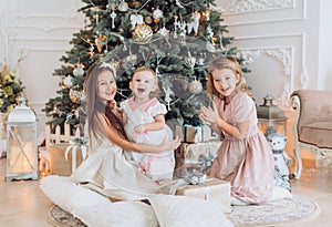 Portrait of three beautiful girls sisters in Christmas decorations