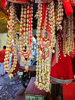 Stock photo of traditional cowry shell garland or kawdyachi mala hanging outside of the shop for sale in the market area.