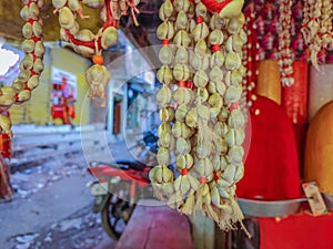 Stock photo of traditional cowry shell garland or kawdyachi mala hanging outside of the shop for sale in the market area, it is