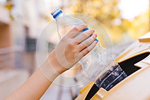 Stock photo of a woman`s hand recycling a plastic bottle