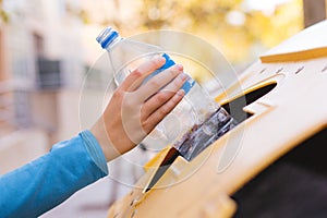 Stock photo of a woman`s hand recycling a plastic bottle